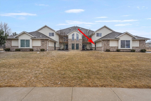 view of front of home featuring a front yard and brick siding