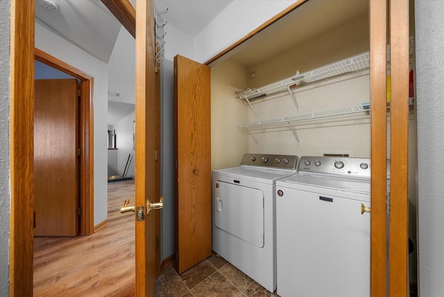 washroom with light wood finished floors, laundry area, and separate washer and dryer