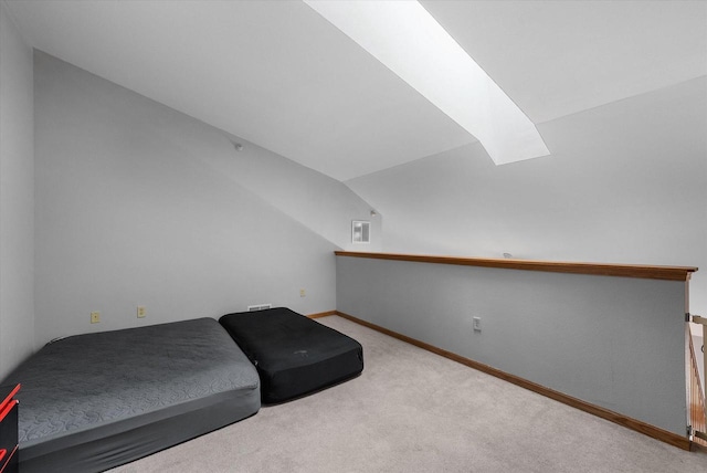 bedroom featuring vaulted ceiling with skylight, carpet, visible vents, and baseboards