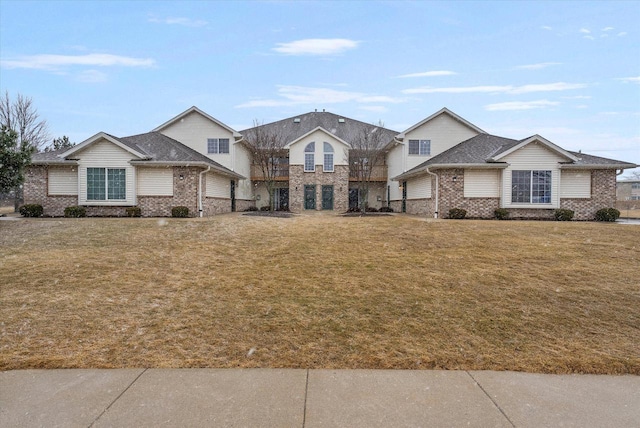 view of front of property featuring a front yard and brick siding