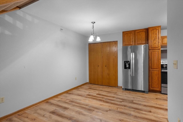 kitchen featuring a notable chandelier, baseboards, appliances with stainless steel finishes, brown cabinets, and light wood finished floors