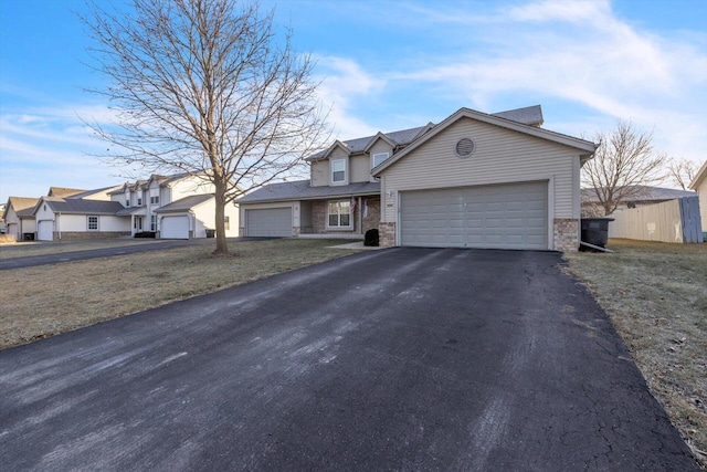 view of front of property featuring an attached garage, a residential view, and aphalt driveway