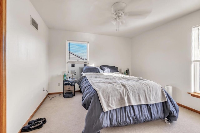 carpeted bedroom with a ceiling fan, visible vents, and baseboards