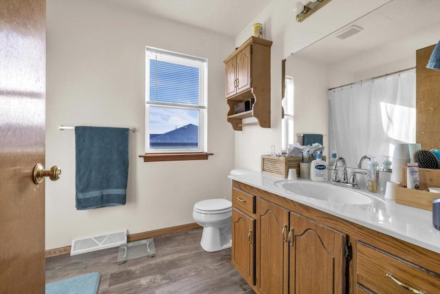 full bathroom with toilet, baseboards, visible vents, and wood finished floors