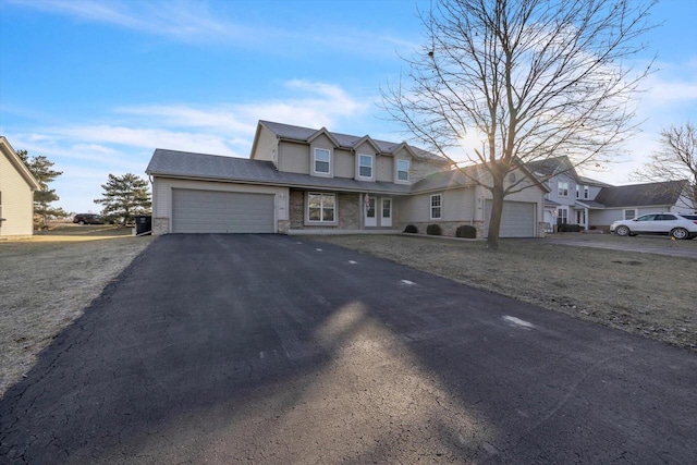 view of front of house featuring a garage, a residential view, and aphalt driveway