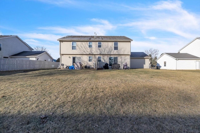 back of house featuring fence and a lawn