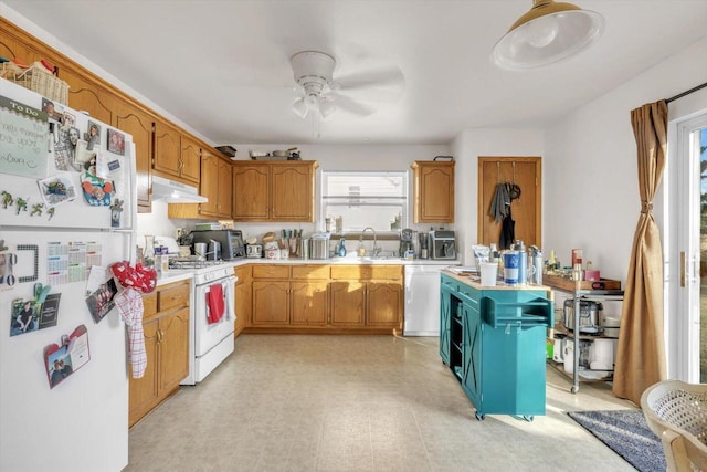 kitchen with white appliances, light countertops, a sink, and under cabinet range hood