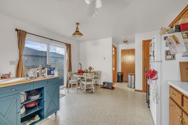 dining room with baseboards, ceiling fan, and light floors