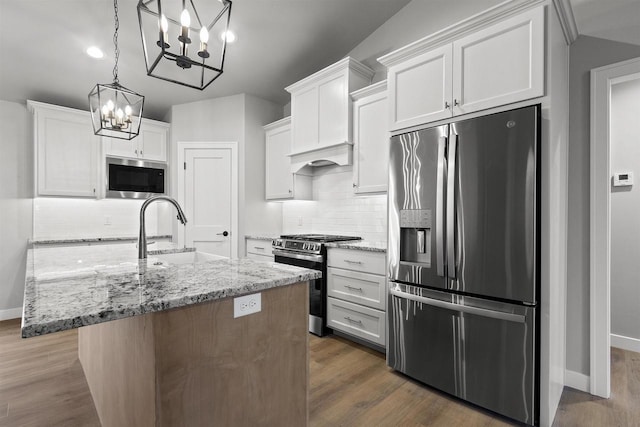 kitchen with appliances with stainless steel finishes, dark wood finished floors, white cabinets, and a sink