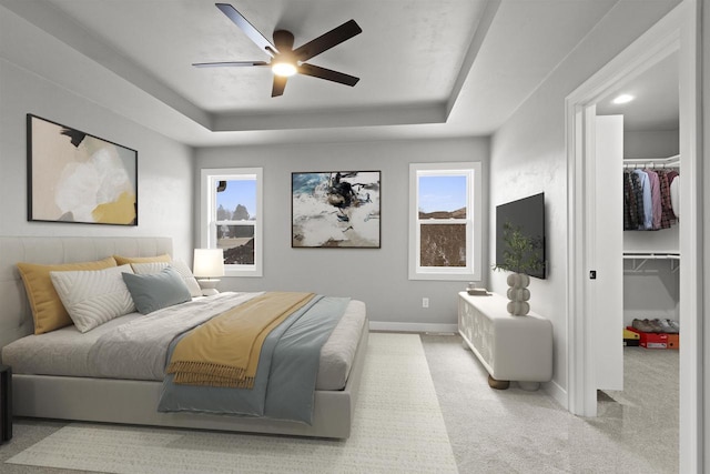 bedroom featuring a tray ceiling, multiple windows, and carpet