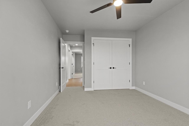 unfurnished bedroom with a ceiling fan, carpet, a closet, and baseboards