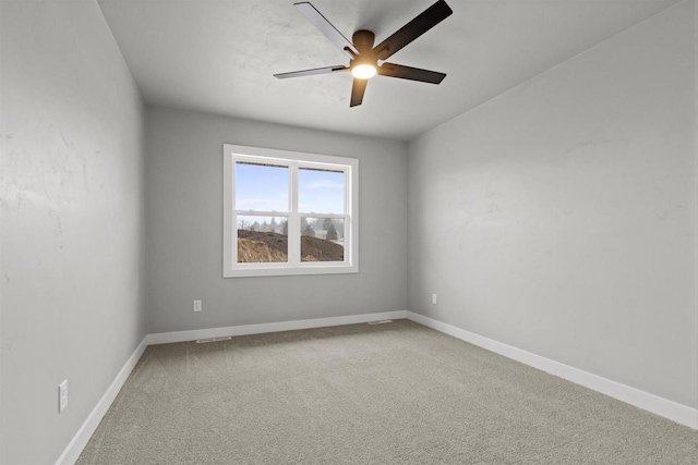 carpeted spare room featuring visible vents, baseboards, and a ceiling fan