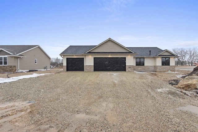 view of front facade featuring stone siding, an attached garage, and dirt driveway