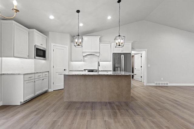 kitchen with stainless steel appliances, white cabinets, visible vents, and light wood-style floors