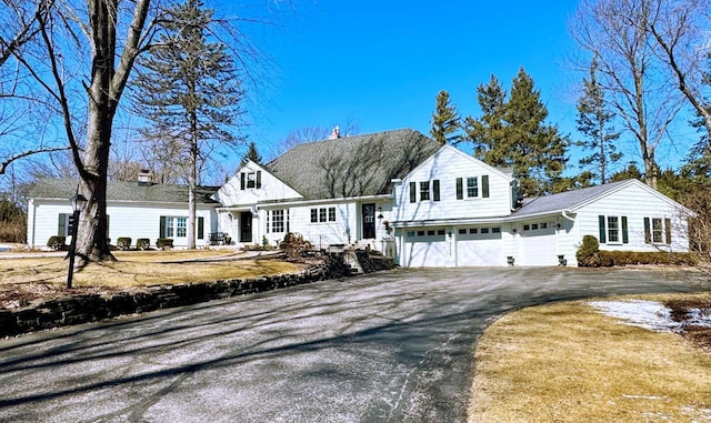 view of front of property featuring driveway and a chimney