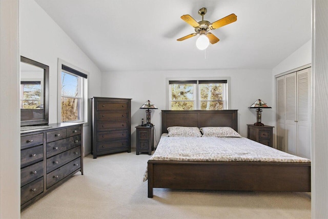 bedroom with vaulted ceiling, multiple windows, a ceiling fan, and light colored carpet