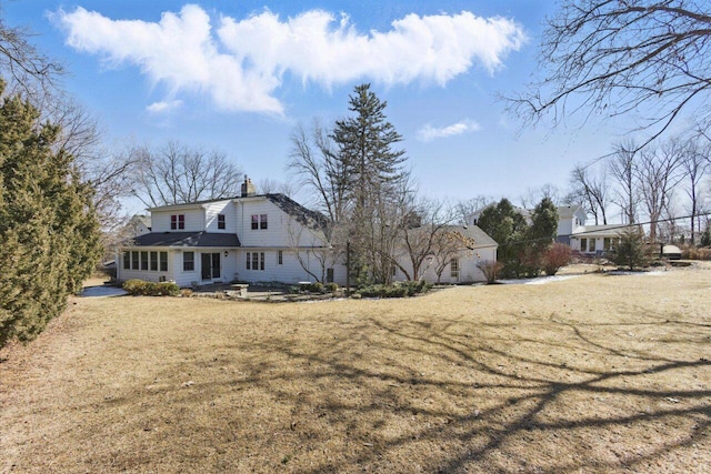 exterior space with a chimney and a front yard