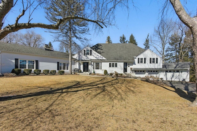 view of front facade with a garage, roof with shingles, a chimney, and a front lawn