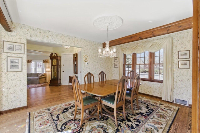 dining room featuring baseboards, light wood-style floors, and wallpapered walls