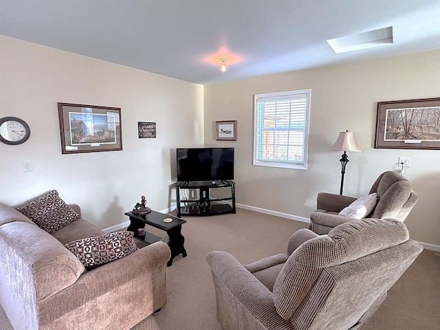 carpeted living area with a skylight and baseboards