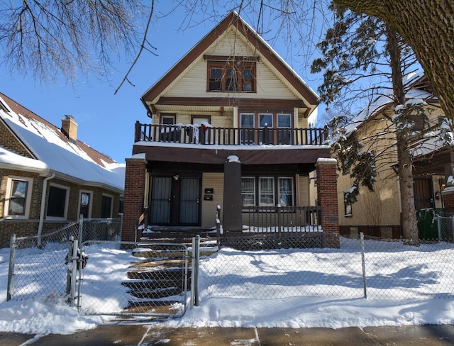 view of front facade with a balcony, covered porch, a fenced front yard, and a gate