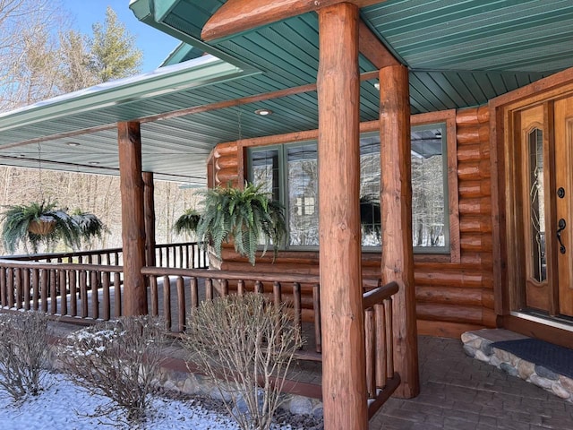 property entrance featuring log siding and covered porch