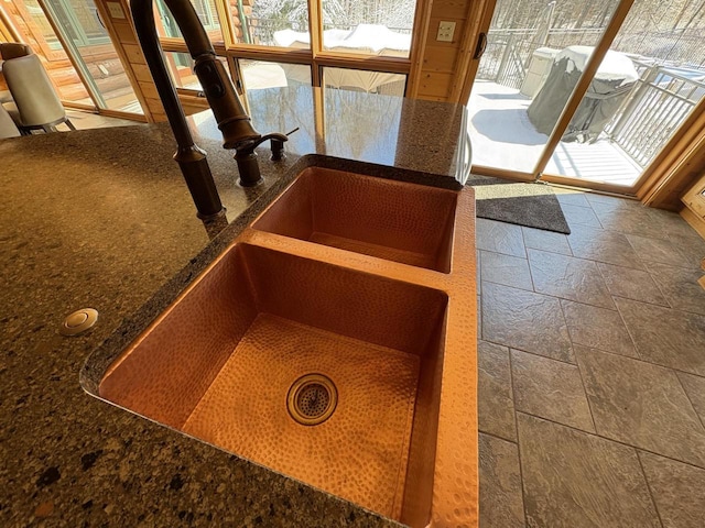 details with a sink and dark stone countertops