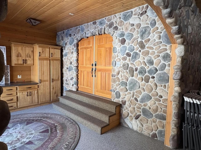 kitchen with wooden ceiling, dark countertops, and carpet