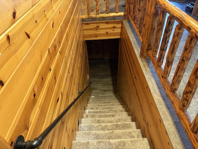 staircase featuring wooden walls