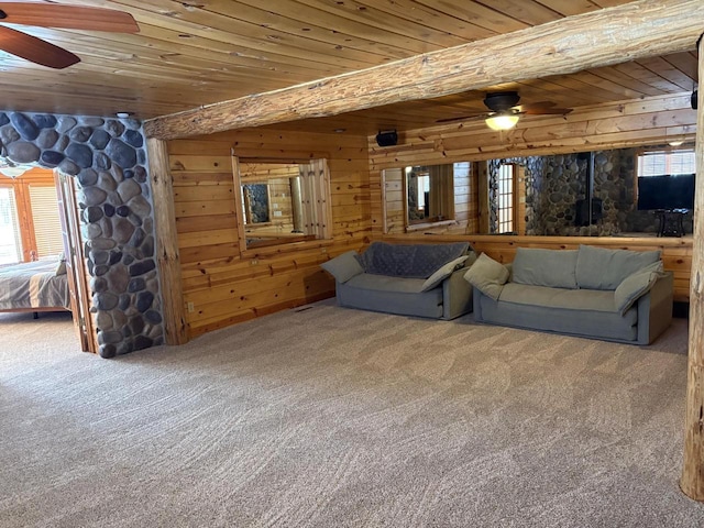 living area with carpet, ceiling fan, wood walls, a wealth of natural light, and wooden ceiling