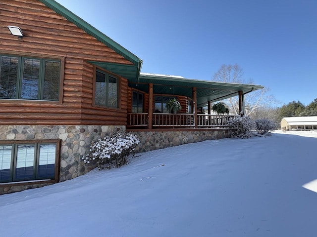 view of snowy exterior with covered porch