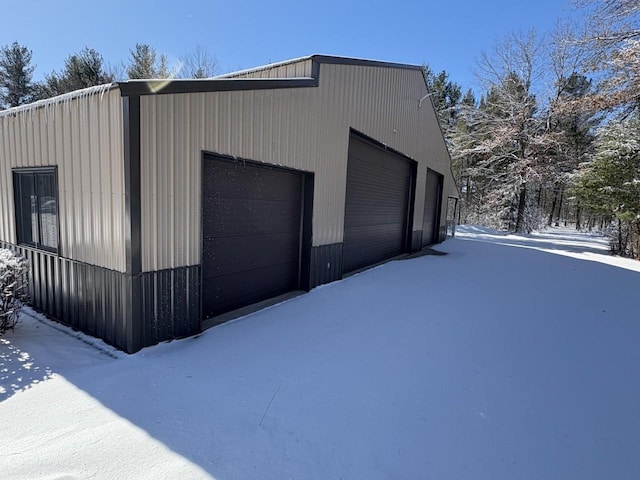 snow covered garage with a detached garage