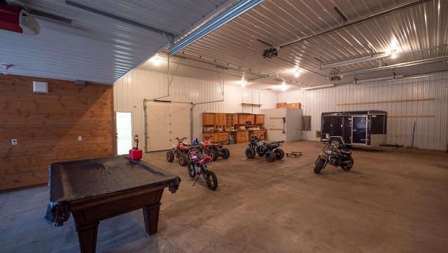 garage featuring a garage door opener and metal wall