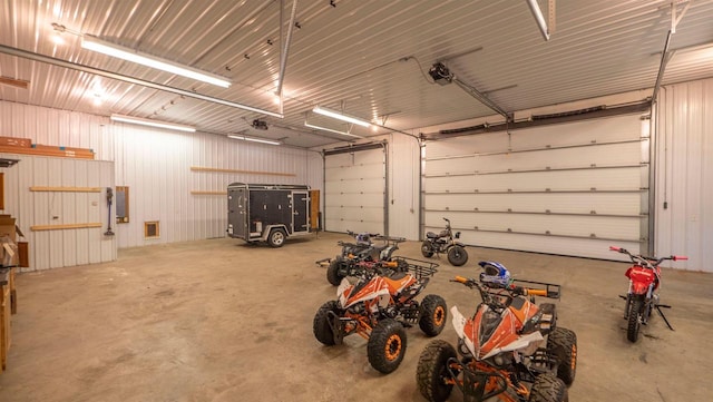 garage with electric panel, metal wall, and a garage door opener