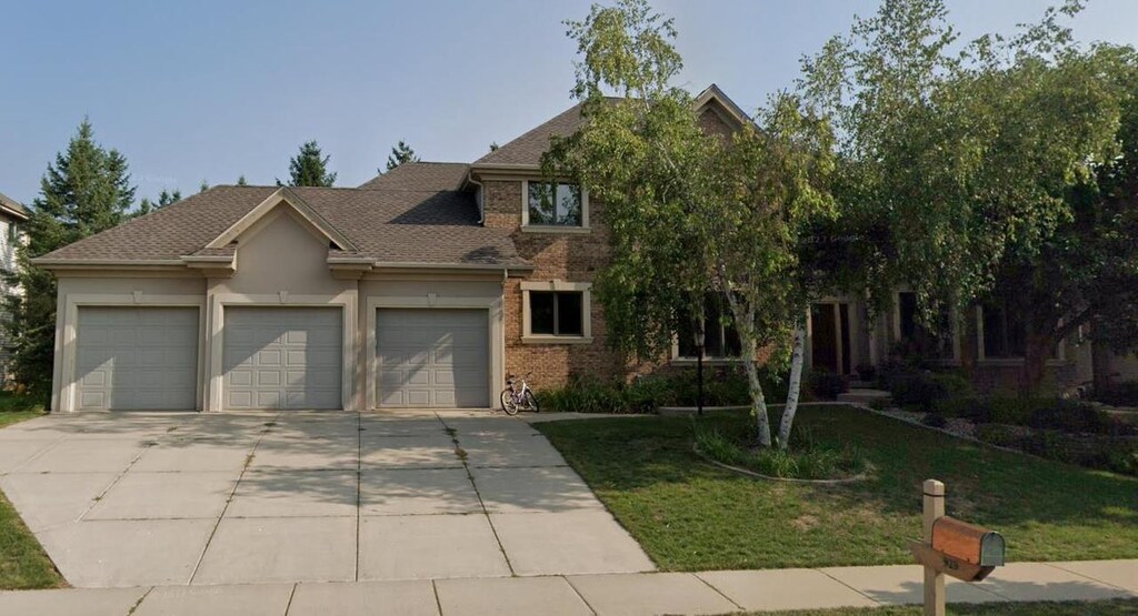 929 Winding Way, Middleton, WI 53562 - view of front of property featuring roof with shingles, driveway, an attached garage, a front lawn, and brick siding