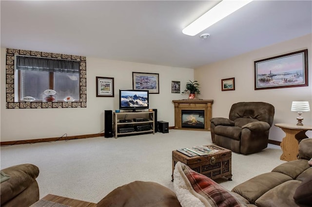 carpeted living area with a glass covered fireplace and baseboards