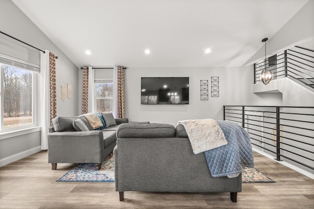 living area with lofted ceiling, recessed lighting, wood finished floors, and baseboards