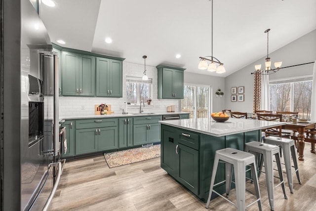 kitchen featuring light countertops, a sink, and green cabinetry