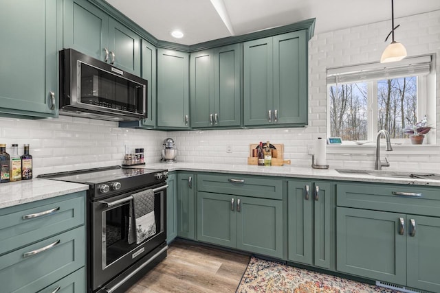 kitchen with black range with electric cooktop, a sink, and green cabinets