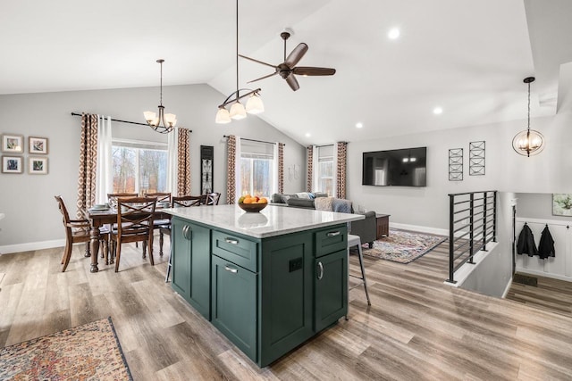 kitchen featuring vaulted ceiling, light wood finished floors, a center island, and green cabinetry