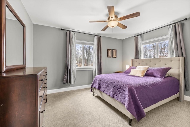 bedroom with light carpet, multiple windows, and baseboards