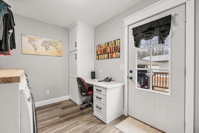 office space with light wood-style flooring, baseboards, and independent washer and dryer