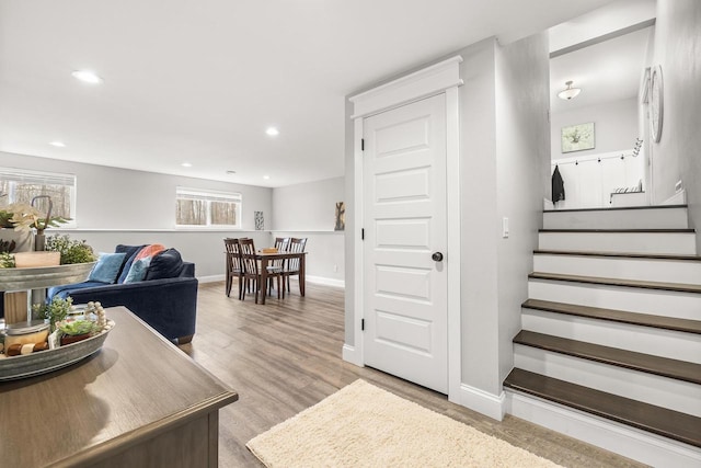 stairway featuring baseboards, wood finished floors, and recessed lighting