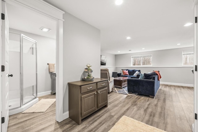 living area with light wood-type flooring, baseboards, and recessed lighting