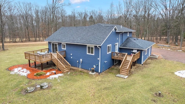 back of property featuring a shingled roof, stairway, a lawn, and a wooden deck