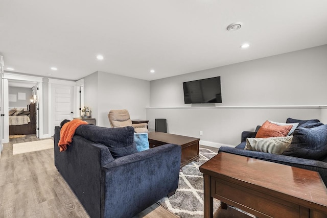 living room with light wood-style floors, recessed lighting, and baseboards