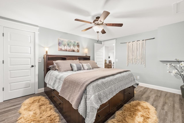 bedroom with visible vents, ceiling fan, baseboards, and wood finished floors