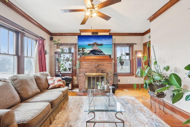 living area with a ceiling fan, baseboards, ornamental molding, and wood finished floors