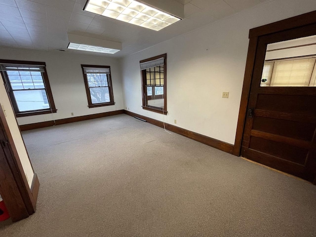 unfurnished room featuring carpet floors and baseboards