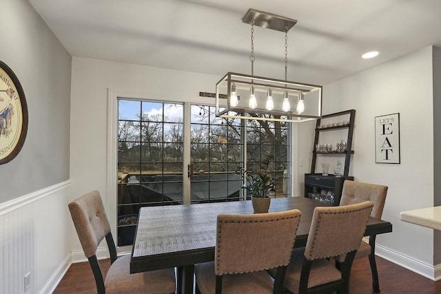 dining space with a wainscoted wall, baseboards, dark wood finished floors, and recessed lighting